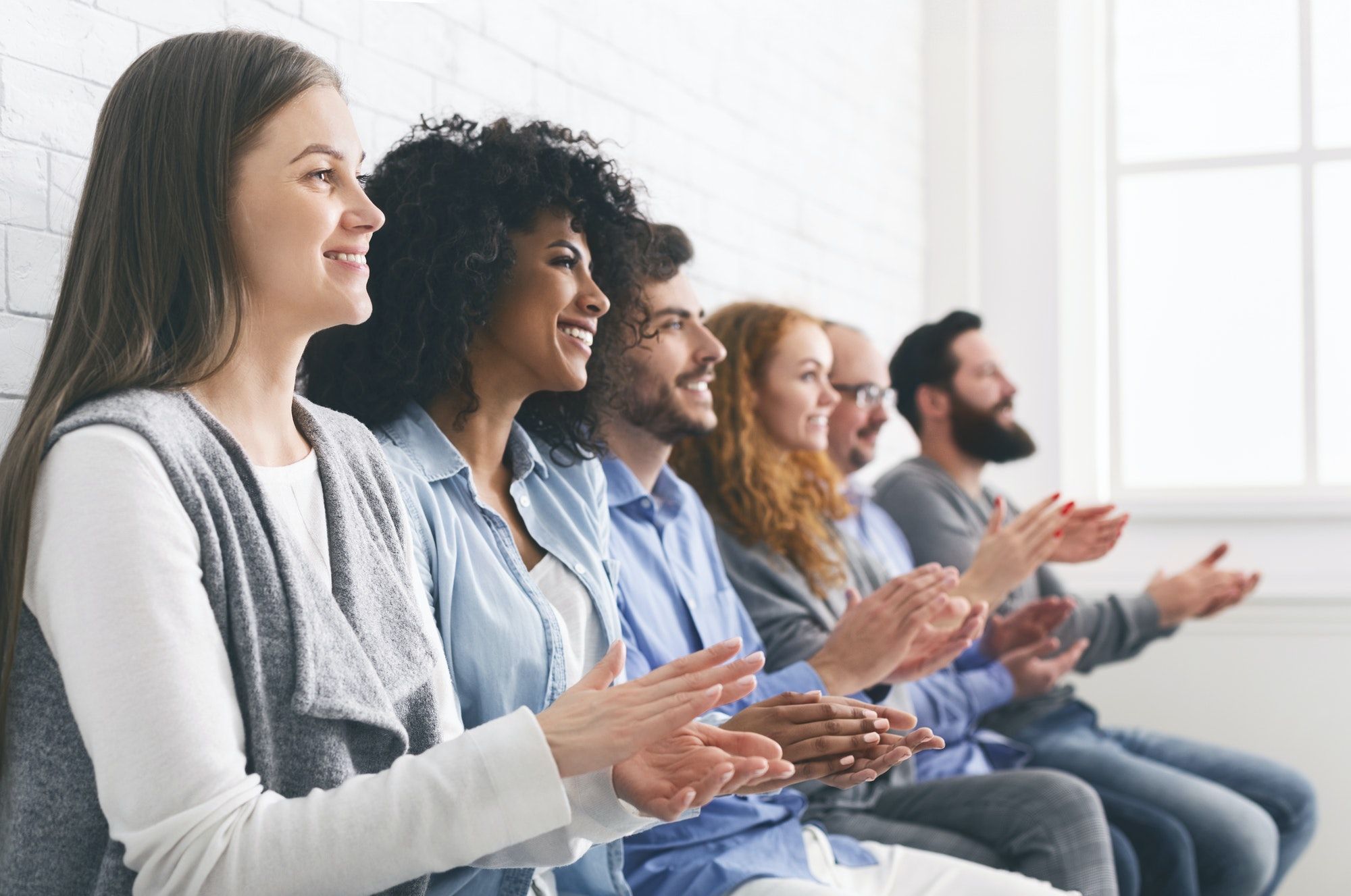 Happy People Sitting In Row Applauding To Mentor At Group Therapy